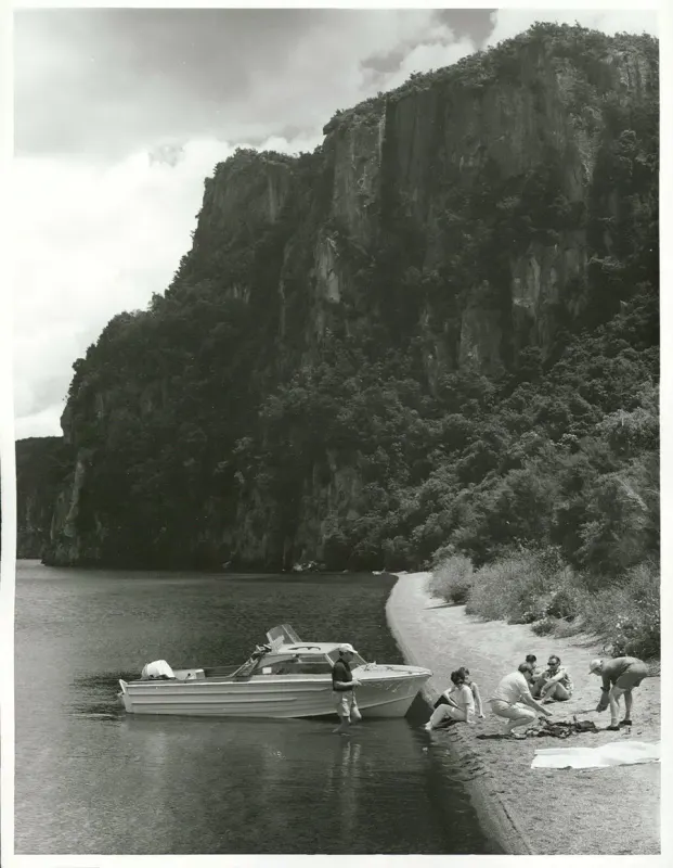 Fishing party on a Lake Taupo beach below lakeside cliffs